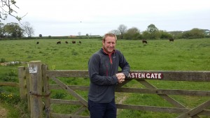 Ed Bramham-Jones, farm adviser, leaning on a fence next to a field